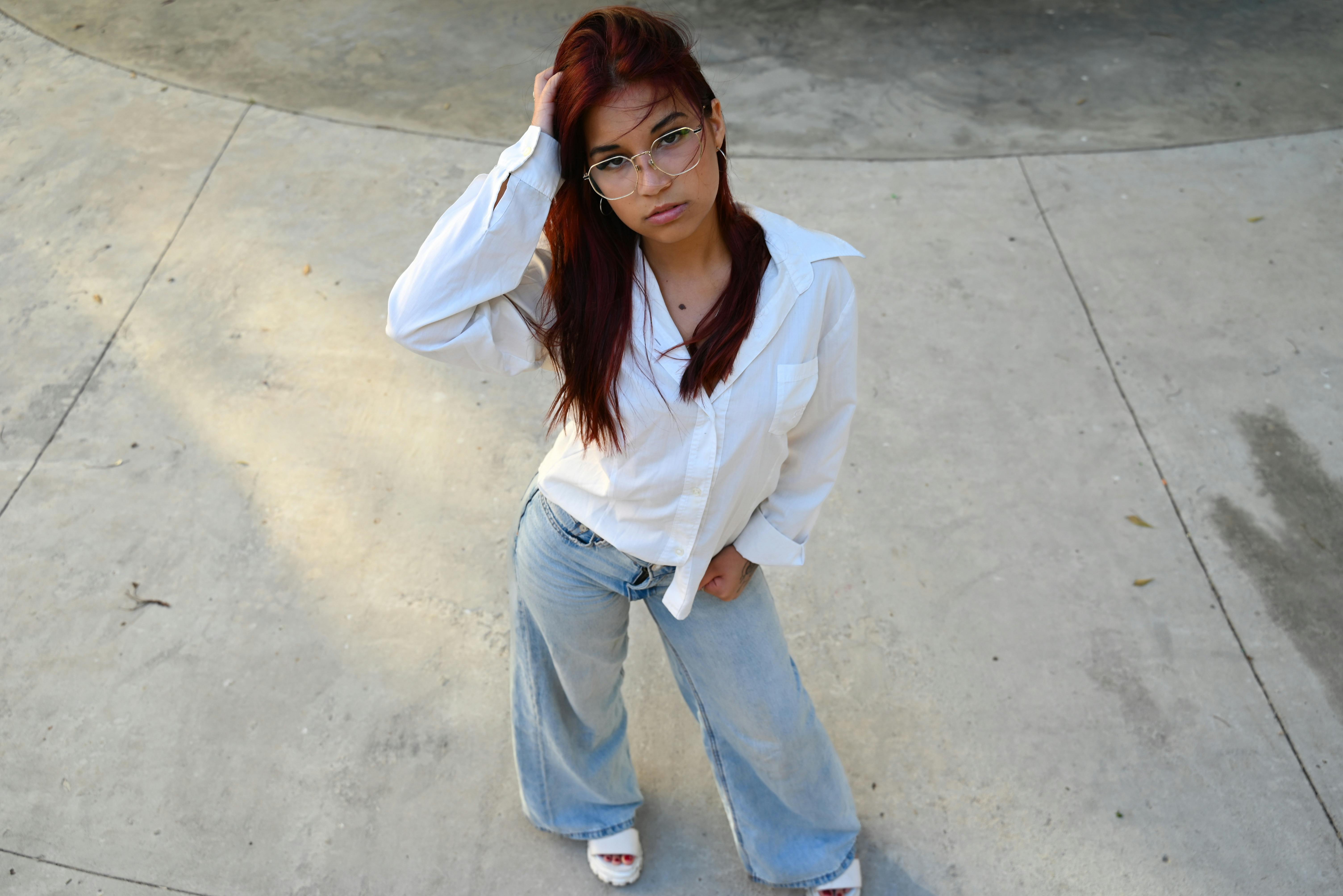Young woman in casual outfit poses confidently outdoors, showcasing modern fashion and style.