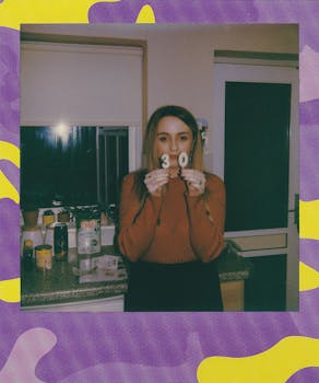 A woman in a kitchen holding '30' candles for her birthday celebration.