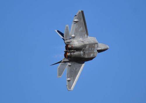 Free A powerful fighter jet soaring through clear blue skies with afterburners blazing, showcasing aviation prowess. Stock Photo