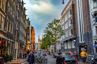 黄昏时分，热闹的阿姆斯特丹街道上，建筑、自行车和城市生活尽显这座城市的独特魅力