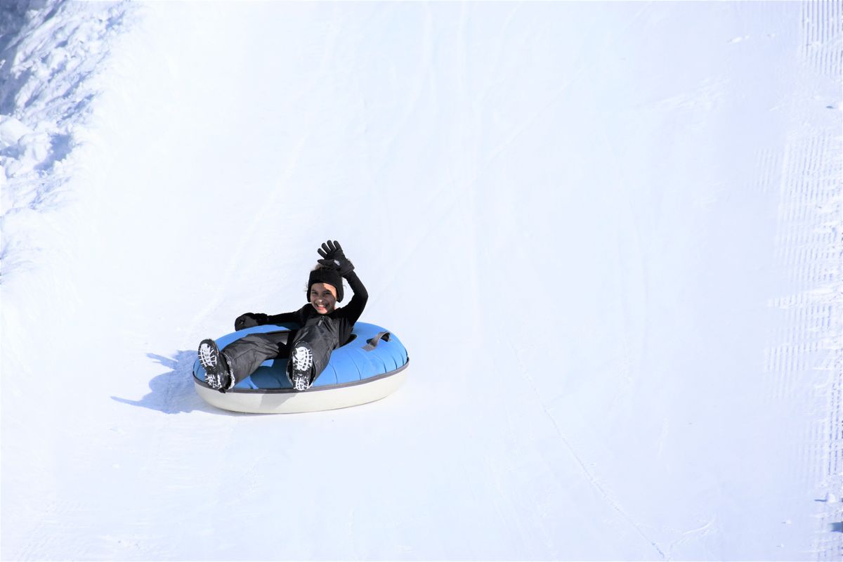 Enfant pratiquant le snowtubing sur une piste enneigée, photo d’ambiance