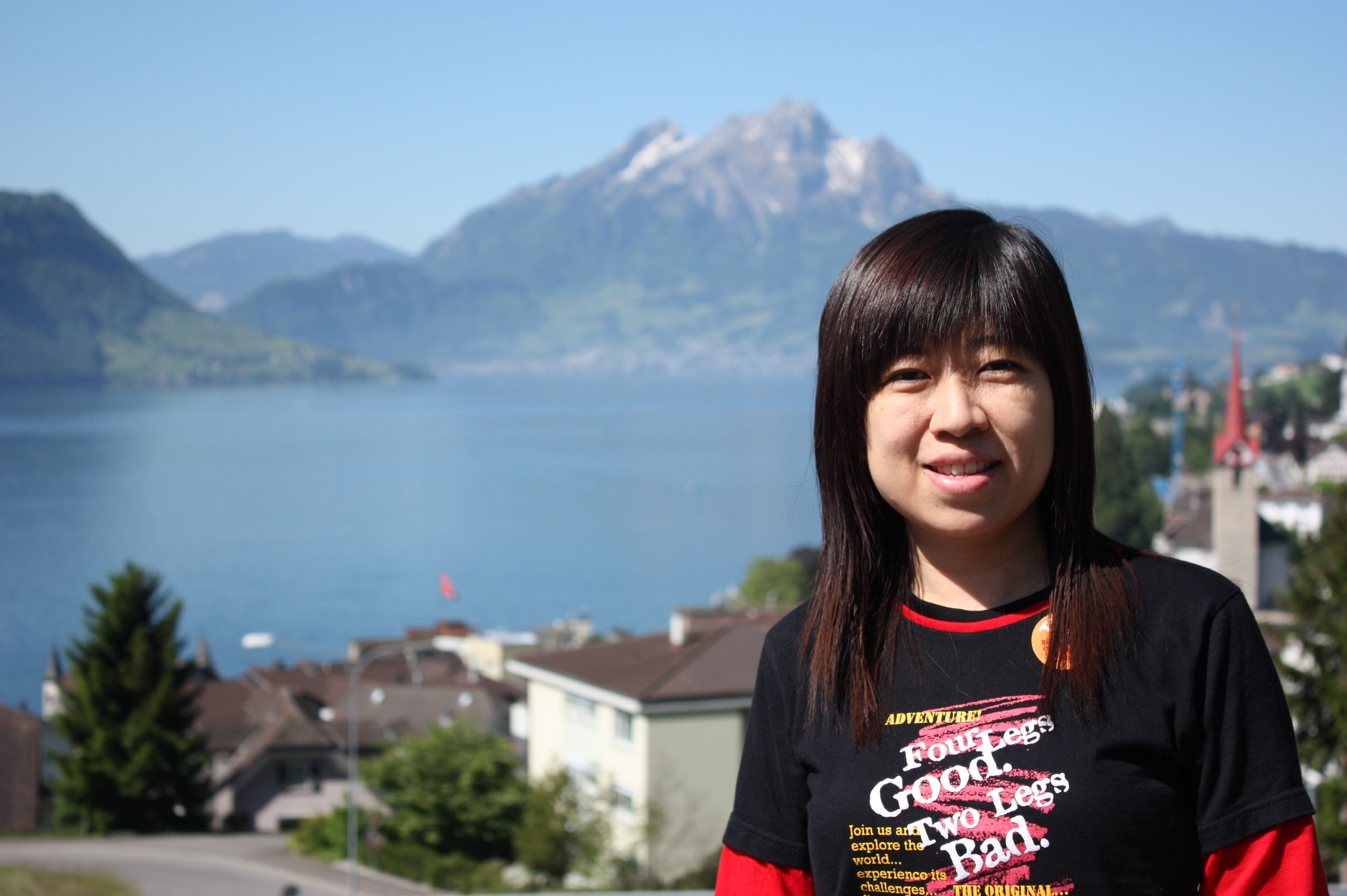 Woman smiling with a picturesque mountain and lake view.