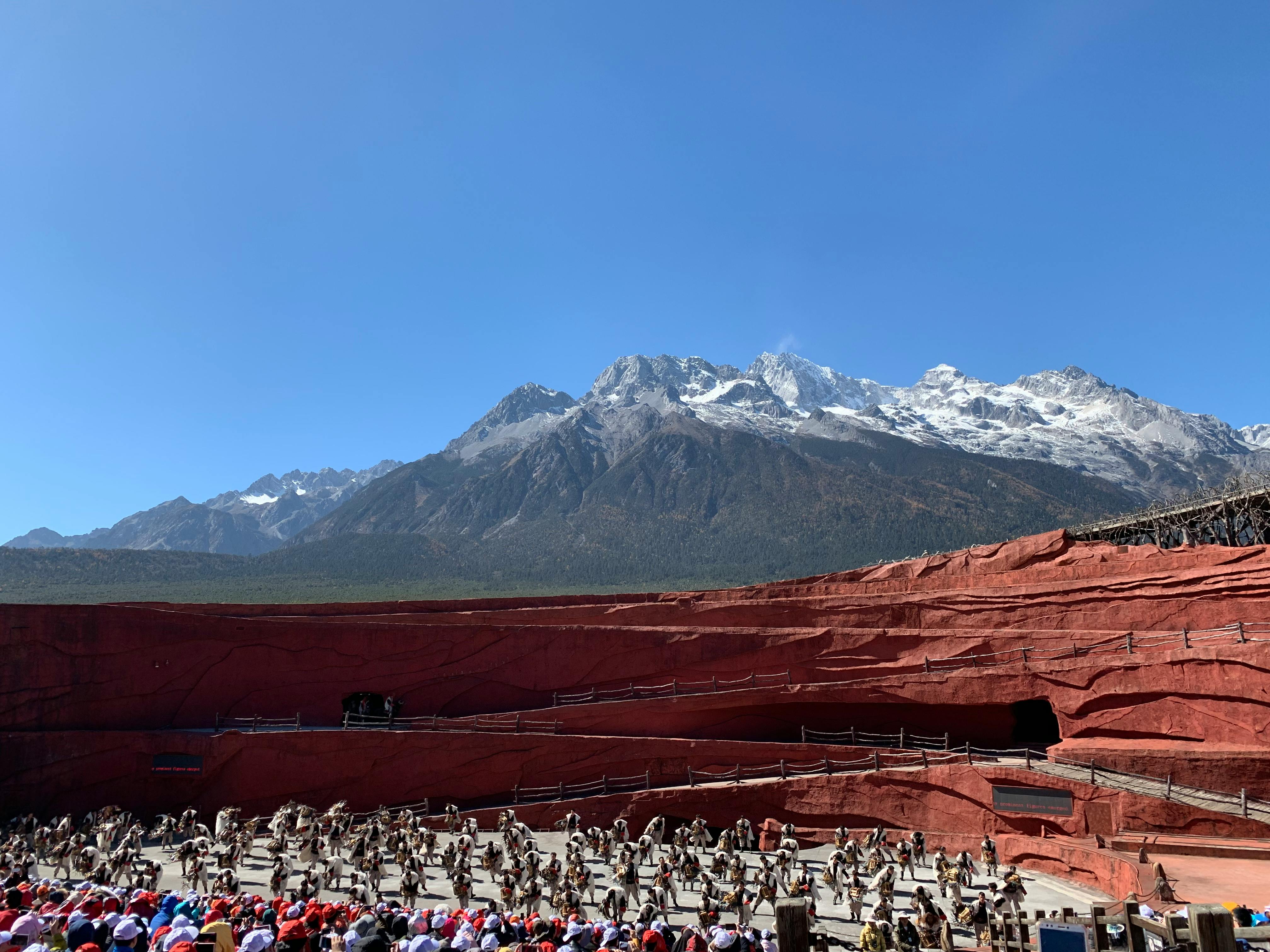 Free Vibrant cultural performance against the stunning Jade Dragon Snow Mountain in China. Stock Photo