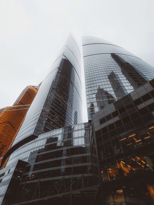 Free Stunning modern skyscrapers reflecting in glass facades under a cloudy sky. Stock Photo