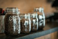 Close-up of labeled glass jars filled with coffee beans on a countertop in Bursa, Türkiye.