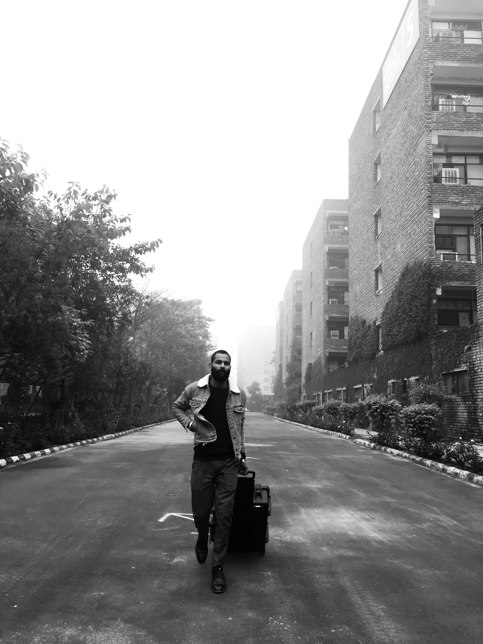 Greyscale Photograph of Man With His Luggage Bag