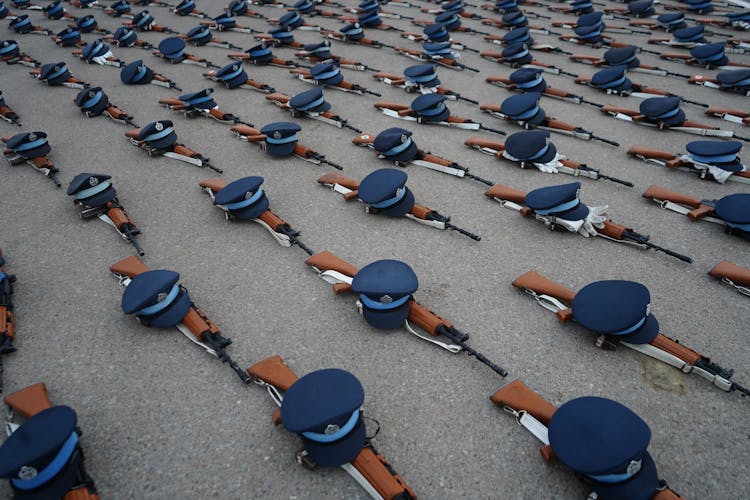 Photo Of Blue Caps And Rifles On Floor