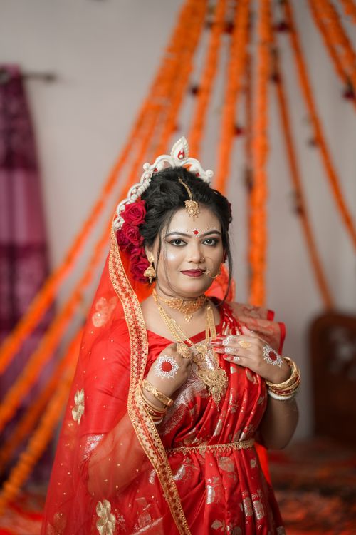 Free Portrait of a beautiful South Asian bride in a traditional red Banarasi saree with gold jewelry. Stock Photo