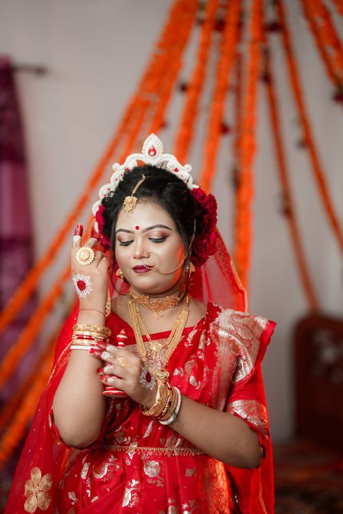 Free A beautiful Bengali bride adorned in traditional attire, showcasing rich cultural heritage. Stock Photo