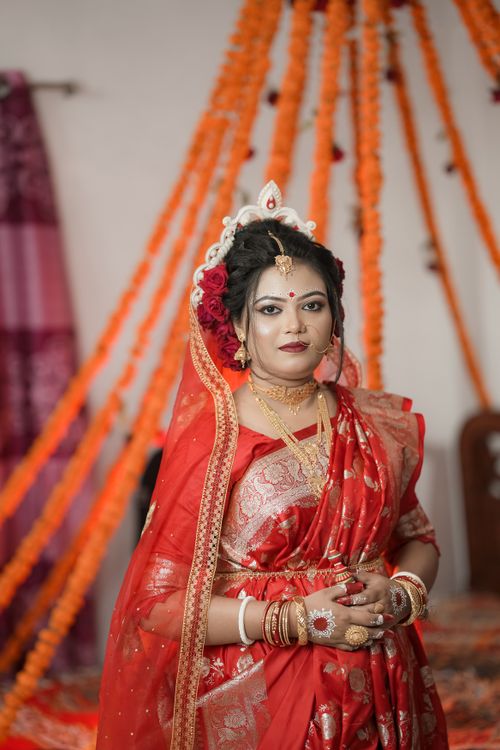 Free Stunning portrait of a South Asian bride in red traditional saree with gold jewelry. Stock Photo