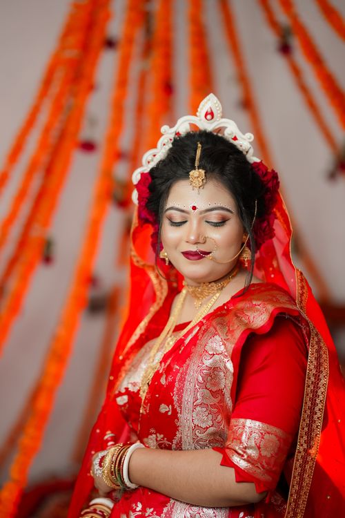 Free A beautiful South Asian bride in traditional attire, adorned with gold jewelry and intricate makeup. Stock Photo