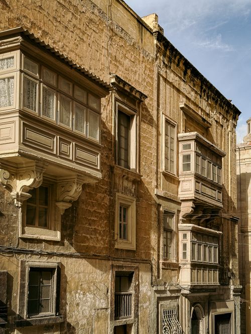 Free Sunlit architecture featuring traditional Maltese balconies in Valletta, Malta's historic capital. Stock Photo