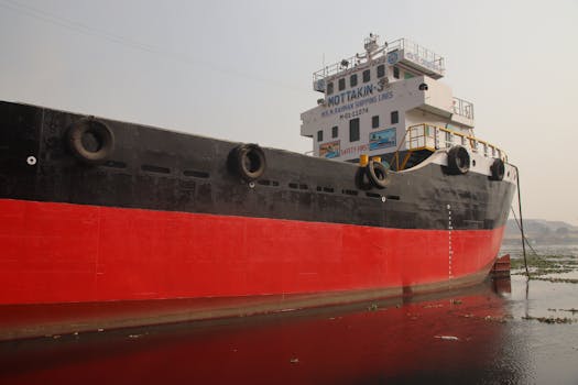 Cargo ship docked on Dhaleshwari River in Keraniganj, Dhaka, Bangladesh, during a clear day.