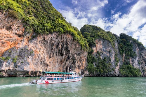 Menschen Auf Dem Schiff, Die Auf Dem Wasser Neben Land Reisen