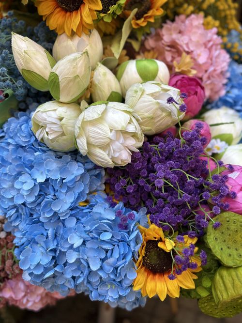 Free A stunning arrangement of sunflowers, lotus buds, hydrangeas, and other vibrant blooms, showcasing nature's beauty. Stock Photo