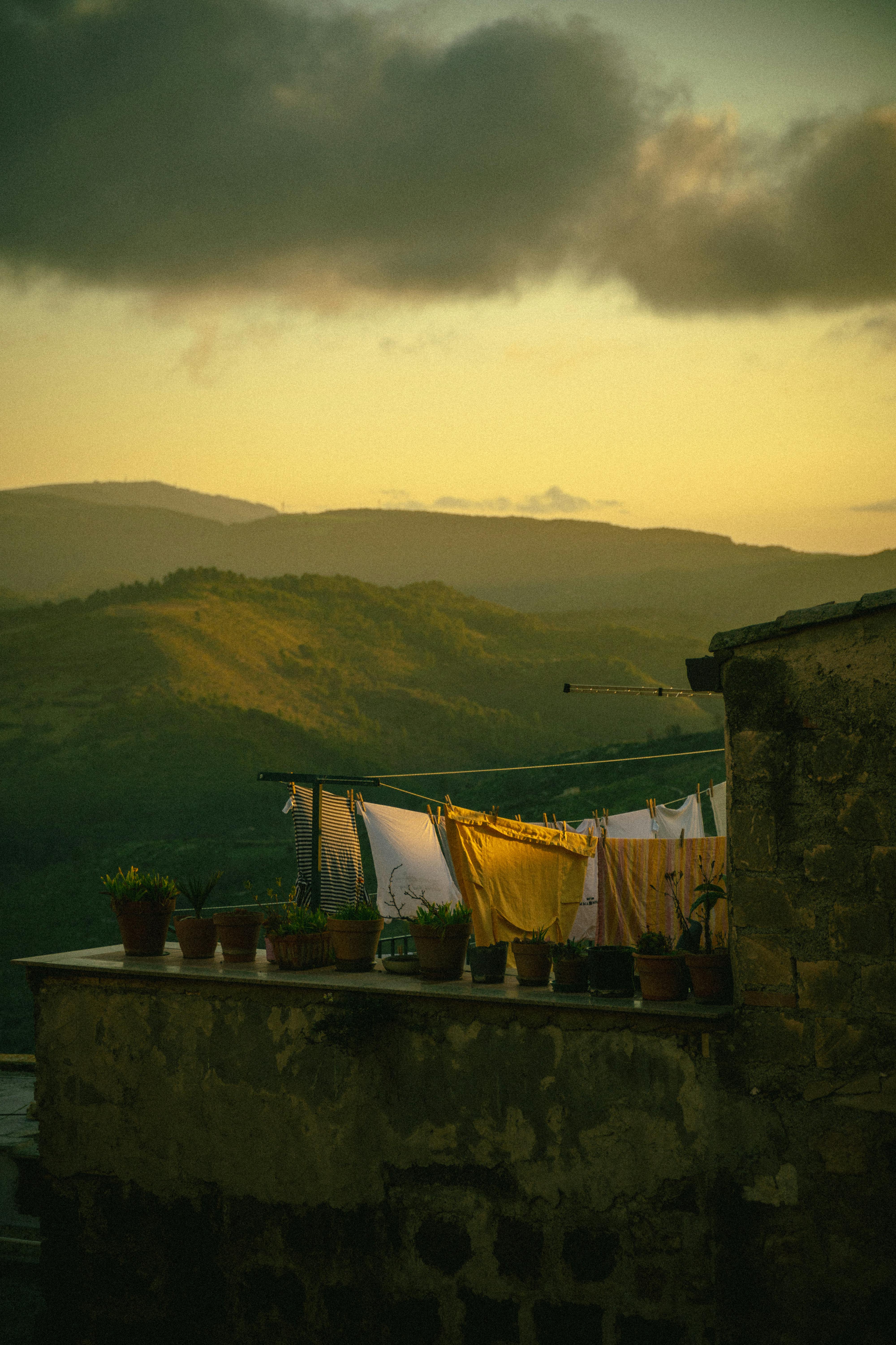 Idyllic sunset view over Vizzini's rolling hills with drying laundry and plants.