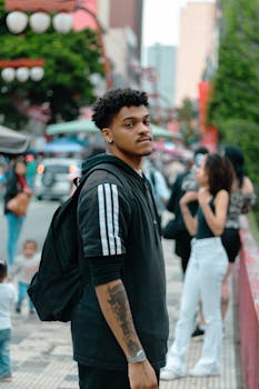 A young man standing on a busy street in São Paulo, Brazil, captures urban culture.