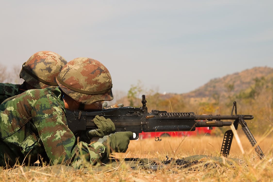 Free Man Lying Forward Using Rifle at the Field during Day Stock Photo
