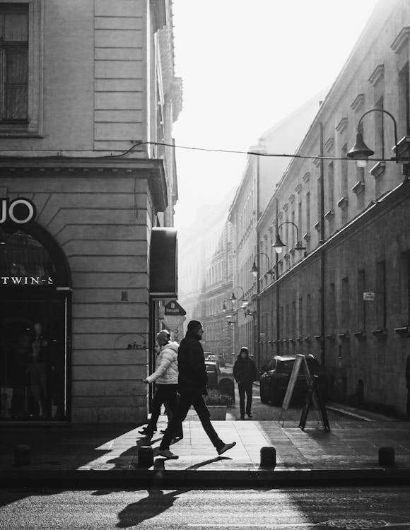 Фотография людей, идущих по тротуару в оттенках серого
