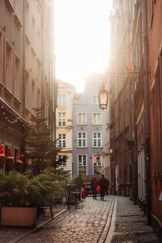A picturesque alleyway in Gdańsk, Poland, illuminated by the warm glow of sunset.