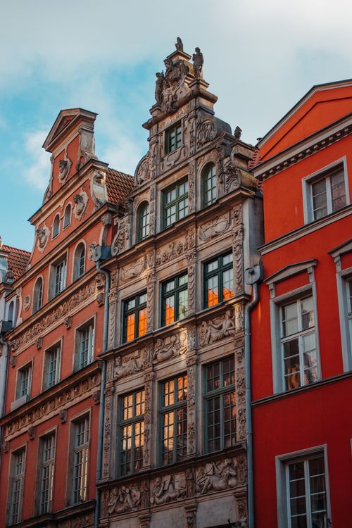 Free Colorful historic buildings in Gdańsk, Poland, with ornate facades lit by sunrise. Stock Photo