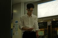 Young Man Adjusting Sleeve in Modern Indoor Setting