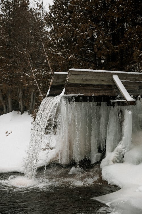 Коричневая деревянная скамья, покрытая снегом