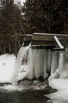 冬季的瀑布风景优美，部分冻结在白雪皑皑的森林景观中