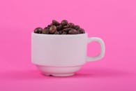 White Coffee Cup with Beans on Pink Background