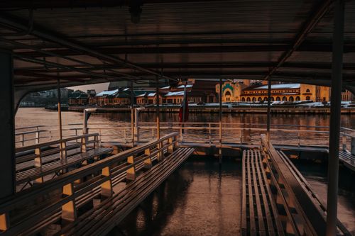Free Empty ferry dock with a view of a colorful waterfront at sunset, offering a peaceful and scenic atmosphere. Stock Photo