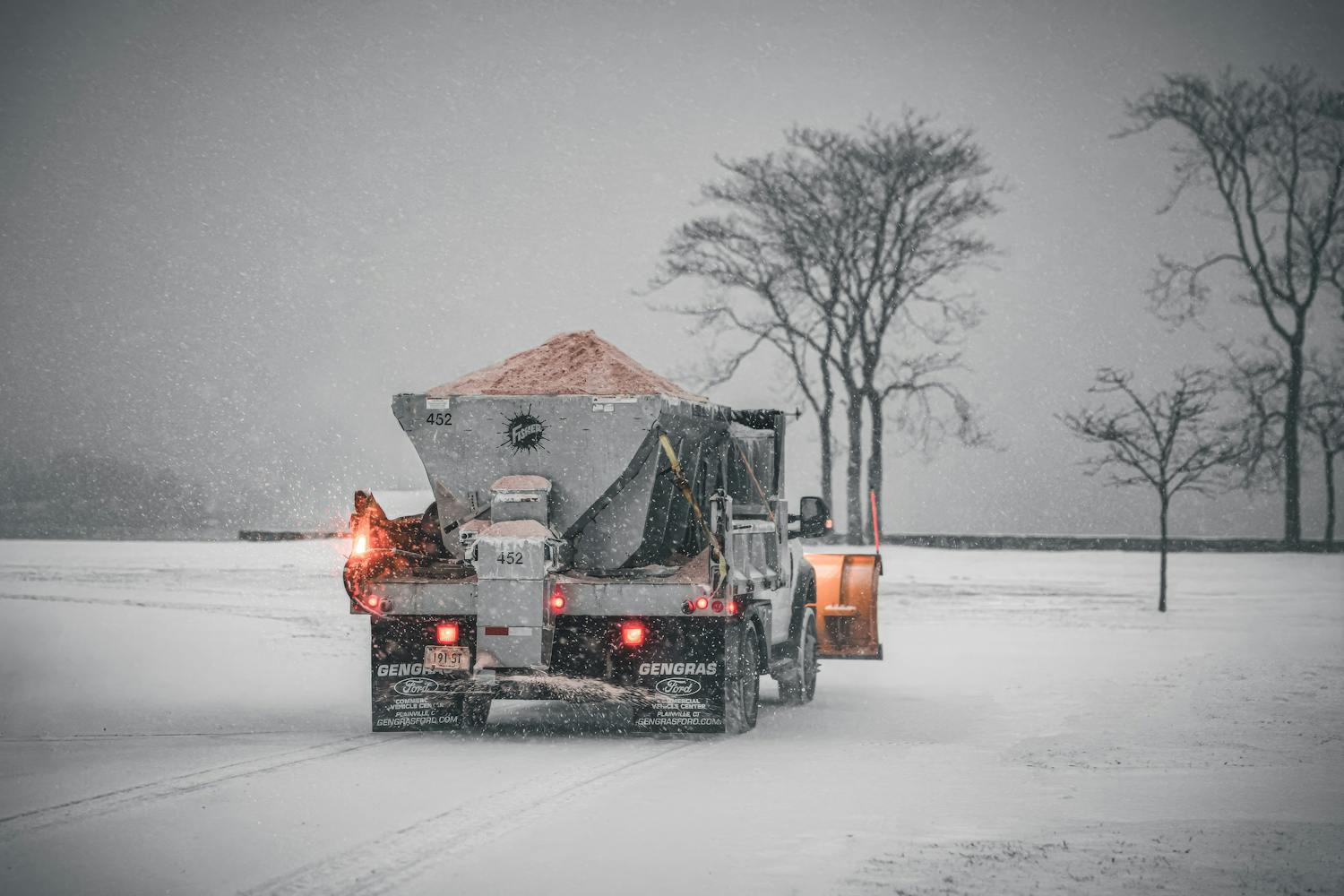 Salt spreading truck treating snowy road surface