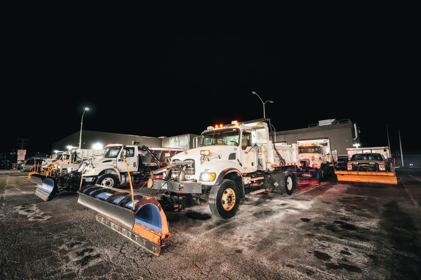 Fleet of plow trucks lined up at night