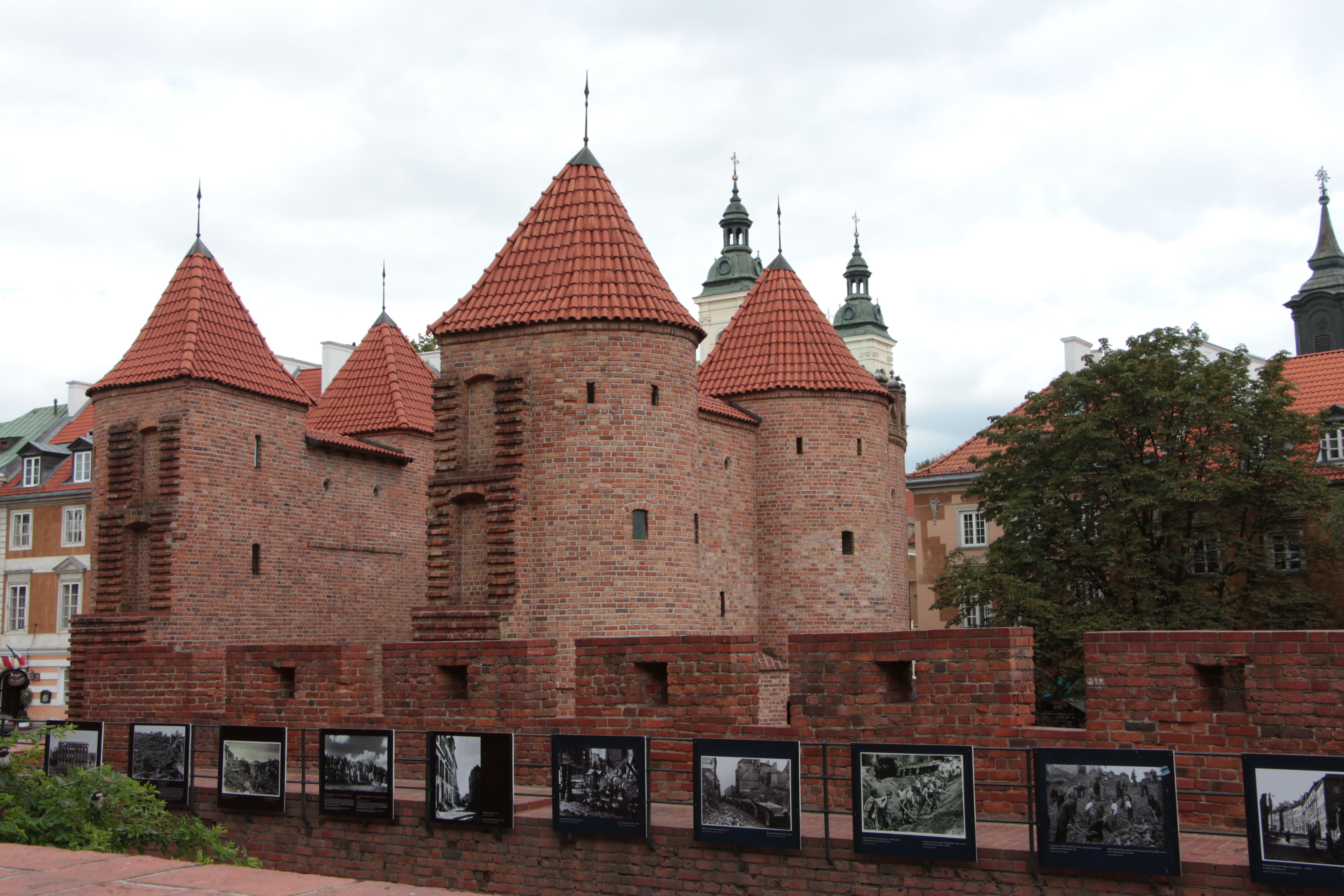 View of Warsaw's iconic Barbican in summer showcasing its red brick towers. - Varsovia