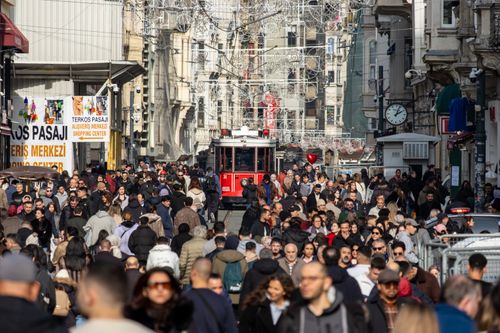 Free Crowded İstiklal Avenue in Istanbul featuring a historic red tram amid a diverse crowd. Stock Photo