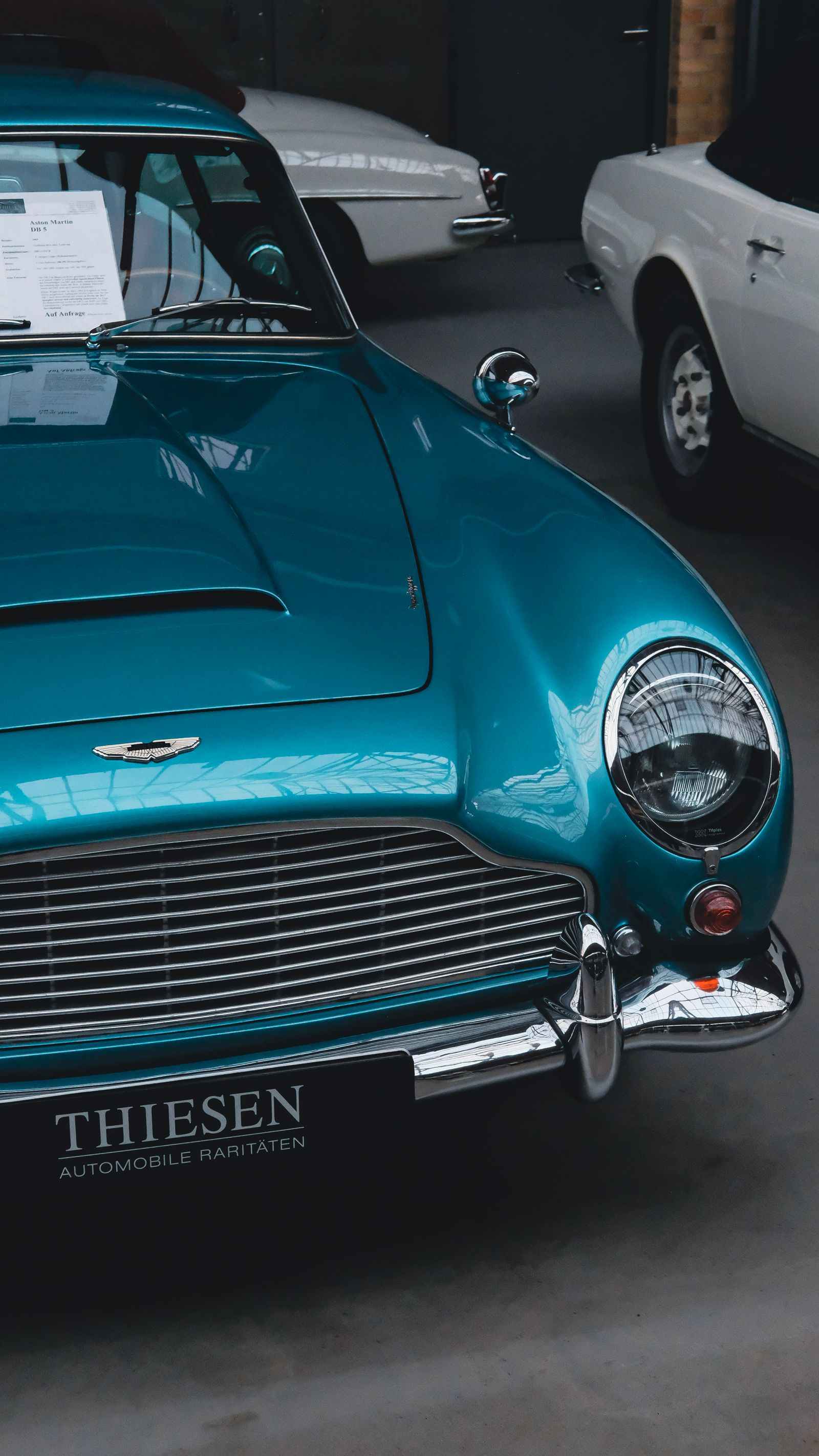 Vintage Aston Martin in a moody indoor showroom