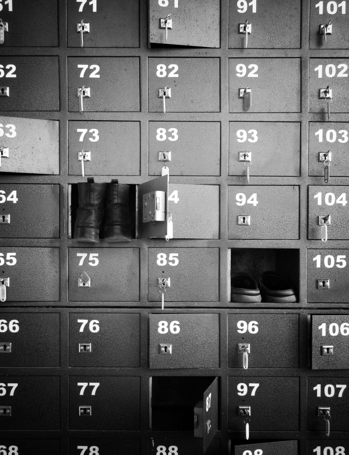 Numbered locker cubbies with open doors holding shoes and boots for each family member