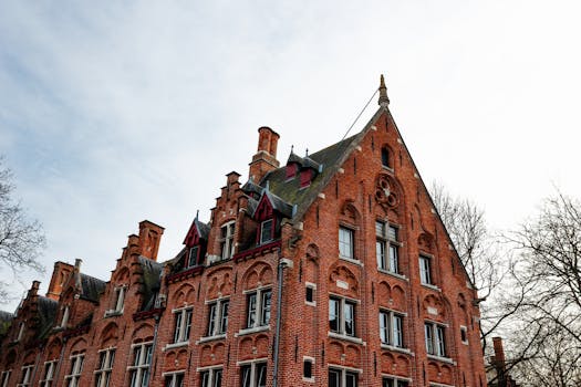 A striking gabled brick building in Bruges, displaying classic Flemish architecture under a bright sky.