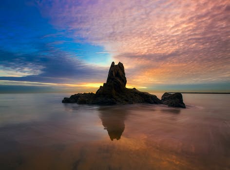 Beautiful sunset over a rocky seascape with vibrant colors and calm waters.