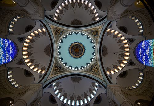 Free A beautifully ornate mosque ceiling featuring intricate patterns and vibrant stained glass. Stock Photo