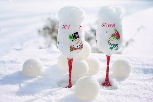 Two White-and-red Snowman-printed Wine Glasses on Snow