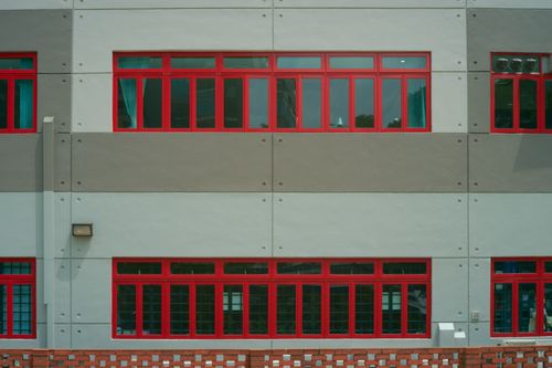 Free Architectural detail of a building facade featuring striking red-framed windows and geometric design. Stock Photo