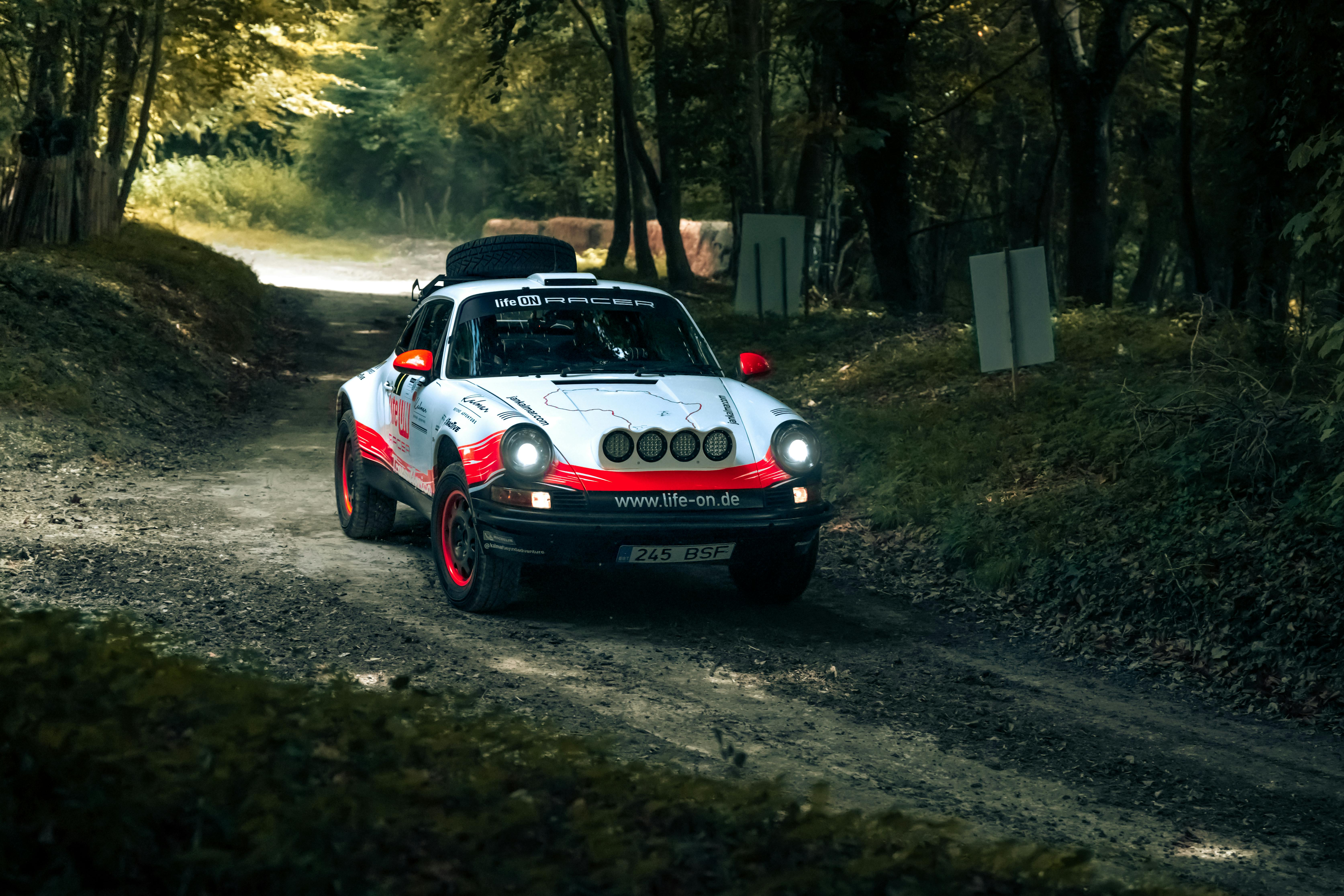 Free Vintage rally car driving through a scenic forest path in Southampton, UK. Stock Photo