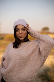 时尚的女人在户外摆放着针织毛衣和无檐帽