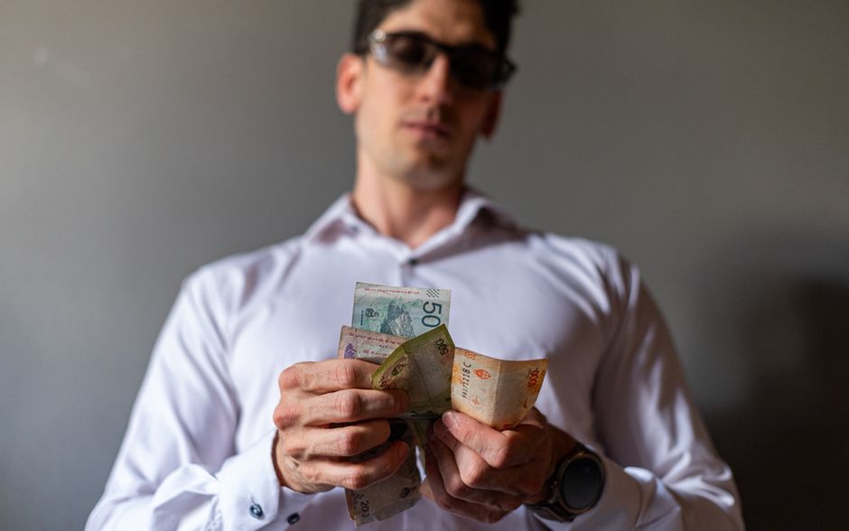 Close-up of a man holding Argentine pesos, representing financial concepts in Buenos Aires. Close-up of a man holding Argentine pesos, representing financial concepts in Buenos Aires.