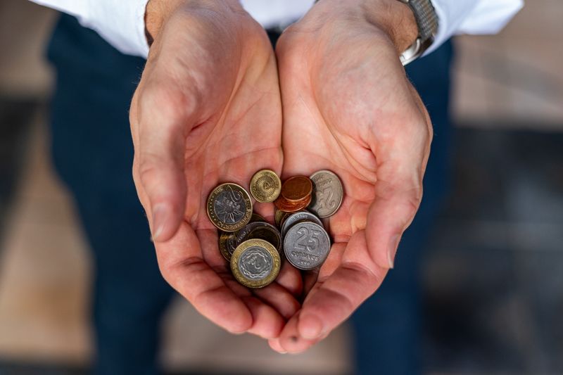 Close-up of hands holding Argentine coins, showcasing currency detail in Buenos Aires.