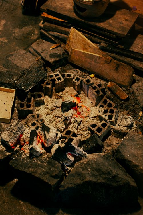 Free A warm charcoal fire surrounded by bricks, ideal for rustic cooking or heating. Stock Photo