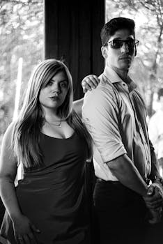 Expressive black and white portrait of two adults with dramatic lighting and timeless style.