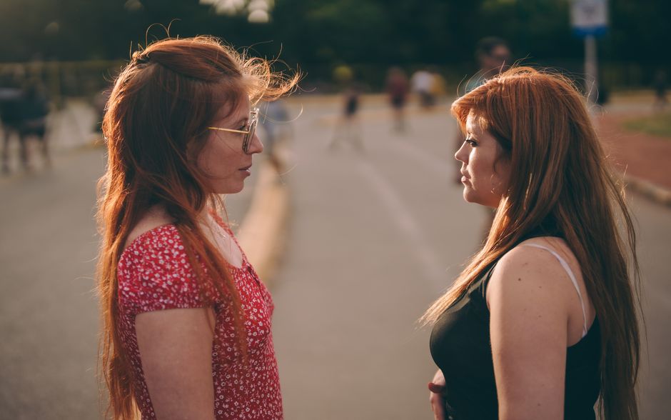 diverse neighbors talking on a suburban street, warm afternoon light, candid community moment