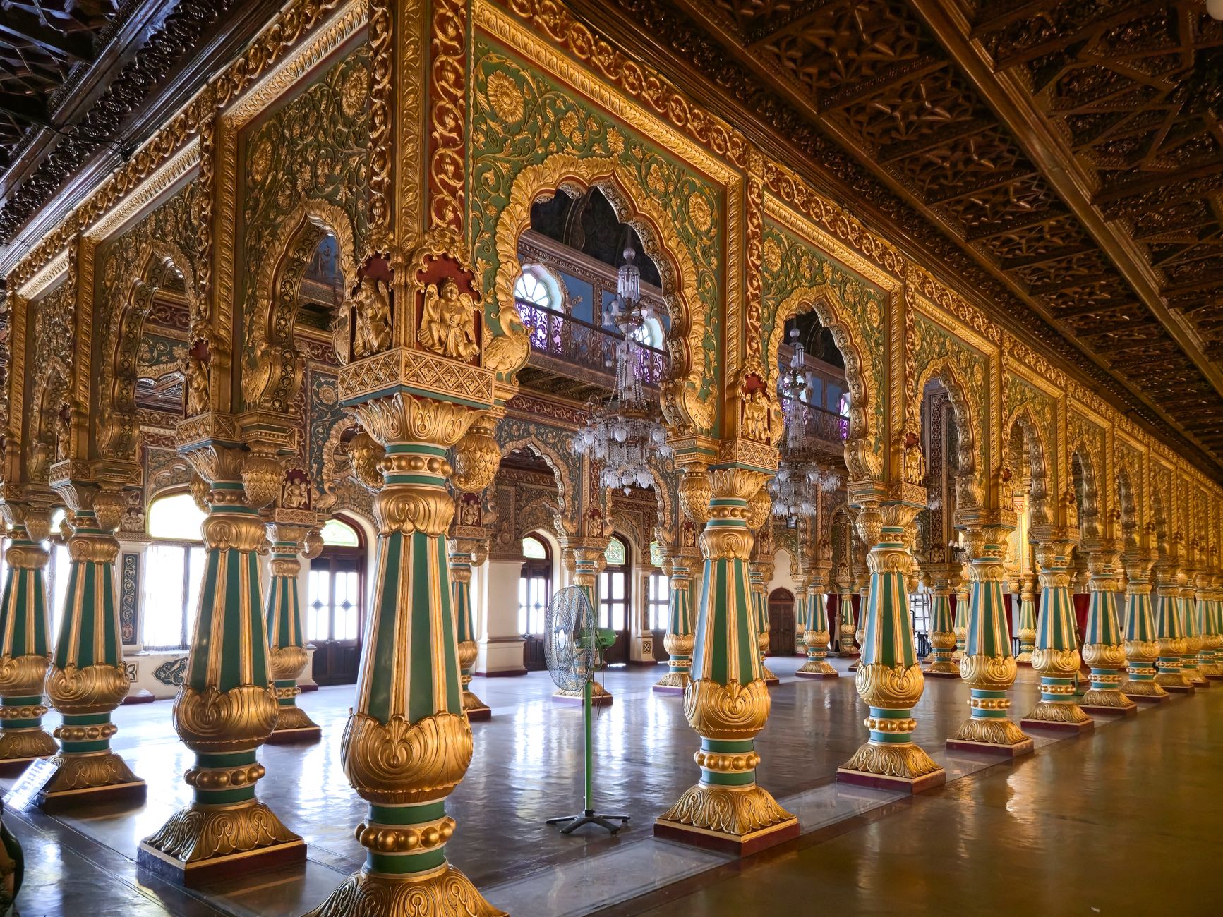 Intricate columns and arches in the opulent hall of Mysore Palace, showcasing detailed Indian architecture.