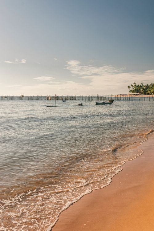 Free Tranquil beach scene in Barra Grande, Bahia, with boats on the ocean. Stock Photo